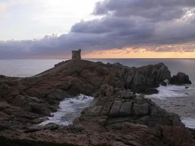 a lighthouse on a rocky island in the ocean at Villa Liamone Studio für 3 Personen , 400 m vom Strand, Pool, Klimaanlage in Sagone