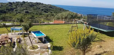 a backyard with a playground with a slide and a swing at Villa Liamone Studio für 3 Personen , 400 m vom Strand, Pool, Klimaanlage in Sagone