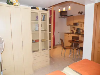 a living room with a large white cabinet and a table at Villa Liamone Studio für 3 Personen , 400 m vom Strand, Pool, Klimaanlage in Sagone