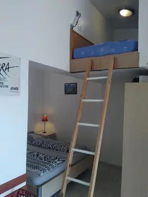 a bunk bed and a ladder in a room at Villa Liamone Studio für 3 Personen , 400 m vom Strand, Pool, Klimaanlage in Sagone
