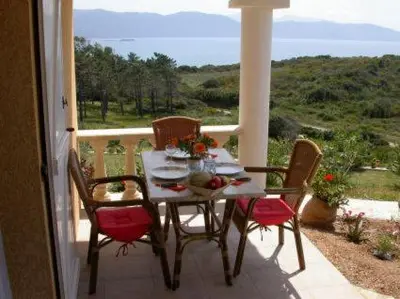a table and chairs on a balcony with a view at Villa Liamone Studio für 3 Personen , 400 m vom Strand, Pool, Klimaanlage in Sagone