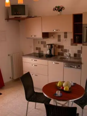 a kitchen with a table with a bowl of fruit on it at Villa Liamone Studio für 3 Personen , 400 m vom Strand, Pool, Klimaanlage in Sagone