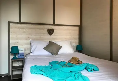 a bed with a blue blanket and a hat on it at U FARNIENTE in Bonifacio