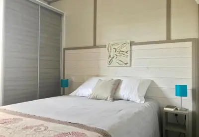 a bedroom with a bed with white sheets and blue lamps at U FARNIENTE in Bonifacio