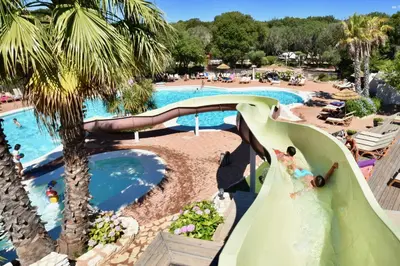 a bride descending a water slide at a resort pool at U FARNIENTE in Bonifacio