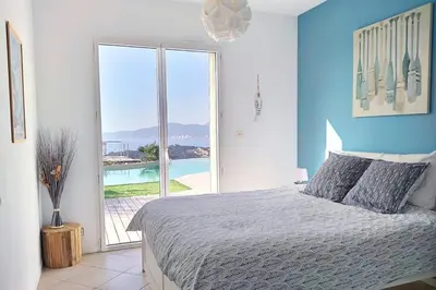 a bedroom with a bed with a view of the ocean at Sole Rossu in Albitreccia