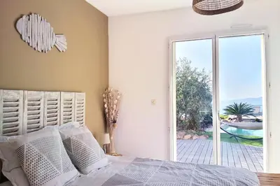 a bedroom with a bed and a sliding glass door at Sole Rossu in Albitreccia