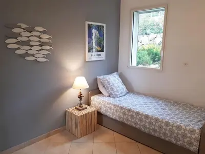 a bedroom with a bed and a lamp and a window at Sole Rossu in Albitreccia