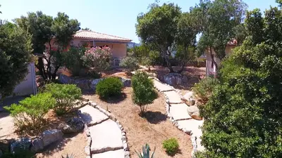 a garden with rocks and trees and a house at SOLE DI DUME in Sotta