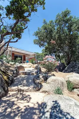 a garden with rocks and trees and a house at SOLE DI DUME in Sotta