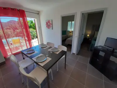 a dining room with a table and chairs and a television at SOLE DI DUME in Sotta