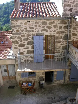 an old stone building with a balcony and a door at mare-monte in Evisa