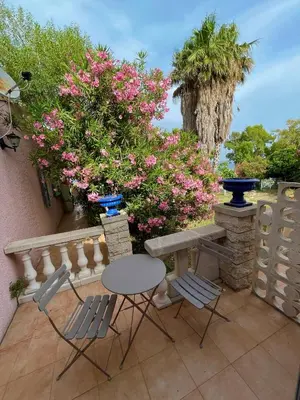 a table and chairs on a patio with pink flowers at Residence VILLA MOROSI - Favone in Conca