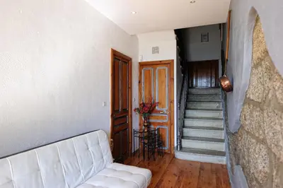a living room with a white couch and a staircase at A Fontana in Zonza