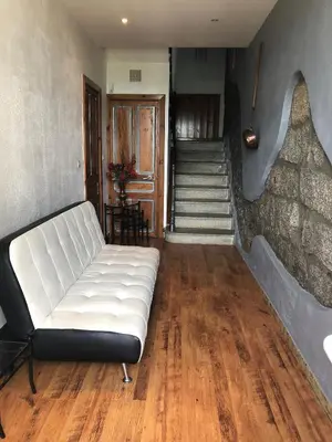 a living room with a white couch and stairs at A Fontana in Zonza