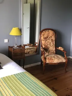 a bedroom with a chair and a mirror at A Fontana in Zonza