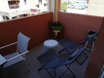 a balcony with chairs and a table on a balcony at Les princes du golf Jerome numero 13 quartier pascal paoli Appartement in Porto-Vecchio