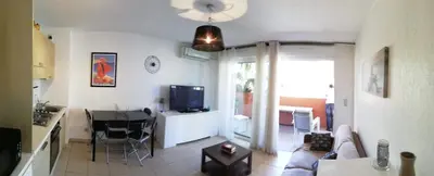 a living room with a couch and a table and a television at Les princes du golf Jerome numero 13 quartier pascal paoli Appartement in Porto-Vecchio