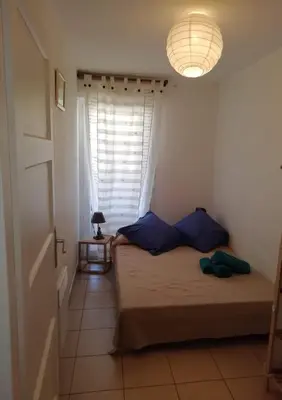 a small bedroom with a bed and a window at Les princes du golf Jerome numero 13 quartier pascal paoli Appartement in Porto-Vecchio