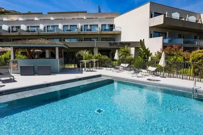 a swimming pool in front of a building at Suite Home Porticcio in Porticcio