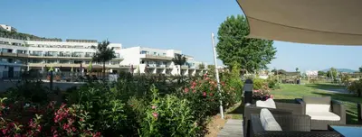a patio with chairs and flowers in front of a building at Suite Home Porticcio in Porticcio