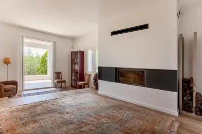 a living room with a fireplace in a white wall at Villa Le Corps de Garde in Furiani