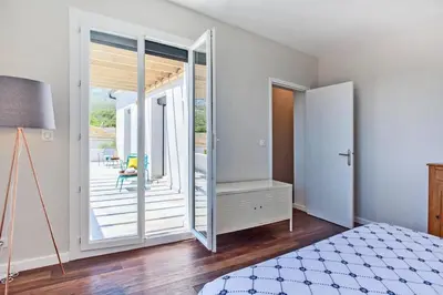 a bedroom with a bed and a sliding glass door at Villa Le Corps de Garde in Furiani