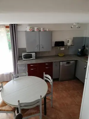 a kitchen with a white table and a table and chairs at Sarrola-Carcopino Gîte en Pierre in Sarrola-Carcopino