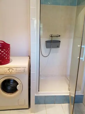 a washing machine in a bathroom with a shower at Sarrola-Carcopino Gîte en Pierre in Sarrola-Carcopino