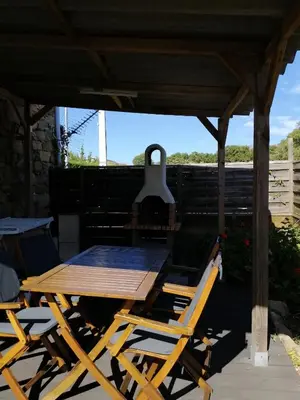 a wooden table and chairs on a patio at Sarrola-Carcopino Gîte en Pierre in Sarrola-Carcopino