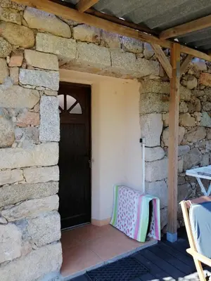 a patio with a black door and a table and chairs at Sarrola-Carcopino Gîte en Pierre in Sarrola-Carcopino