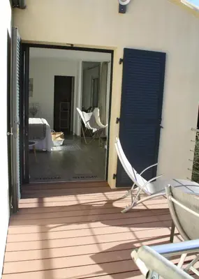 a patio with chairs and a sliding glass door at L'oliveraie du Fango in Manso