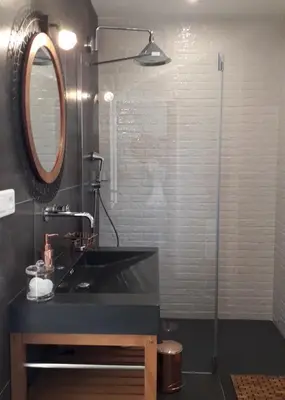 a bathroom with a black sink and a mirror at L'oliveraie du Fango in Manso