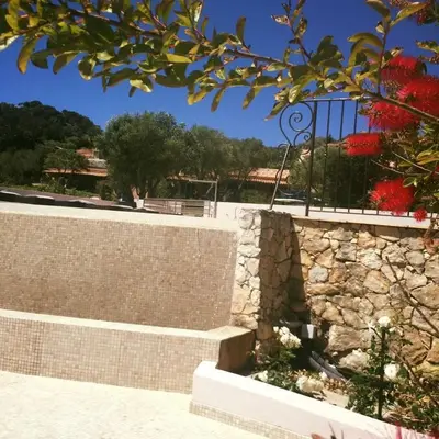 a brick retaining wall with a stone wall at Hôtel Maora Village in Bonifacio