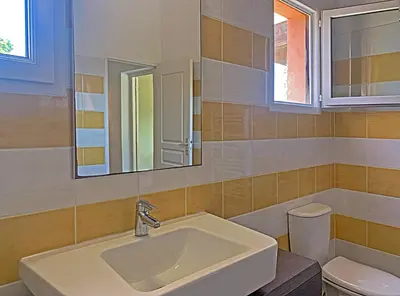 a bathroom with a sink and a toilet and a mirror at Résidence Maora Village in Bonifacio