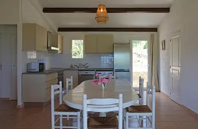 a kitchen with a table and chairs in a kitchen at Résidence Maora Village in Bonifacio
