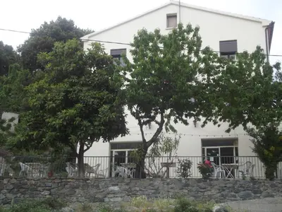 a white house with trees in front of it at Hotel U Liccedu in Bustanico