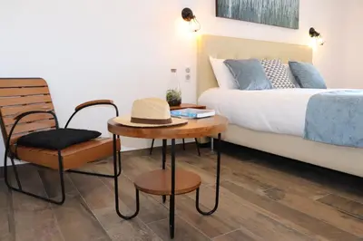 a bedroom with a bed and a chair and a table at Hotel Fazio in Bonifacio