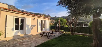 a small house with a picnic table in a yard at Gîte A l'ombre du clocher in Calenzana