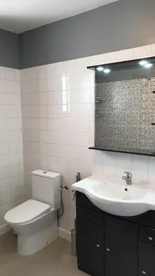 a bathroom with a toilet and a sink and a mirror at Gîte A l'ombre du clocher in Calenzana