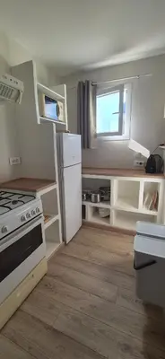 a small kitchen with a stove and a refrigerator at Gîte A l'ombre du clocher in Calenzana