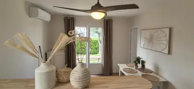 a dining room with two white vases on a table at Gîte A l'ombre du clocher in Calenzana