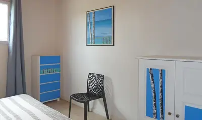 a bedroom with a chair and a picture on the wall at Locations 