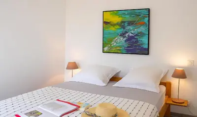 a bedroom with a bed with a painting on the wall at Locations 