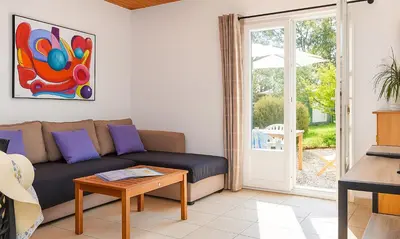 a living room with a couch and a sliding glass door at Locations 