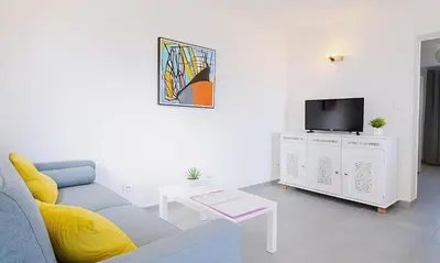 a living room with a blue couch and a tv at Locations 
