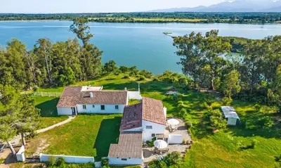 an aerial view of a house on the shore of a lake at Locations 