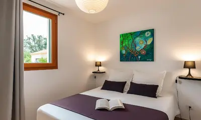 a bedroom with a bed with two books on it at Locations 