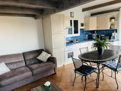 a living room with a couch and a table and chairs at Hameau de pietra longa Salvini PORTO-VECCHIO in Sotta