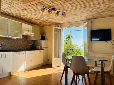 a kitchen with a table and a dining room at Hameau de pietra longa Salvini PORTO-VECCHIO in Sotta